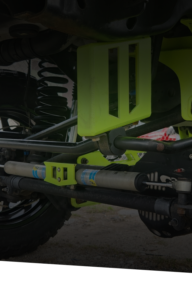 Bright green custom suspension components on a black Jeep.