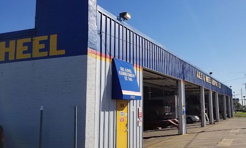 Exterior of a blue and yellow car wash with multiple bays.