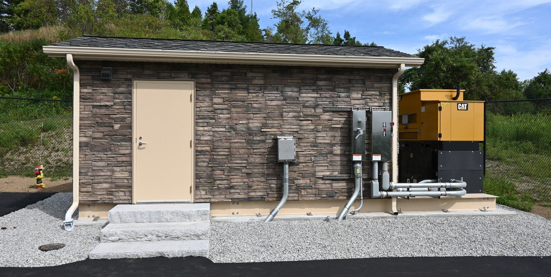 A small brick building with a door and stairs