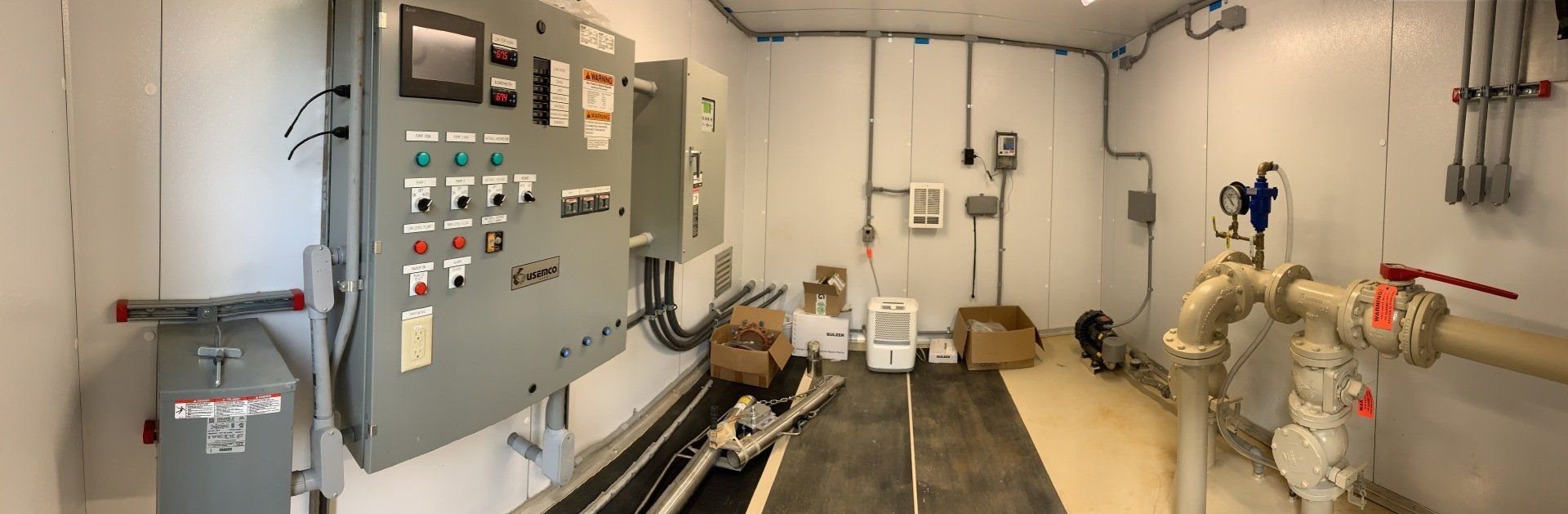 A large room with a lot of electrical equipment on the wall.