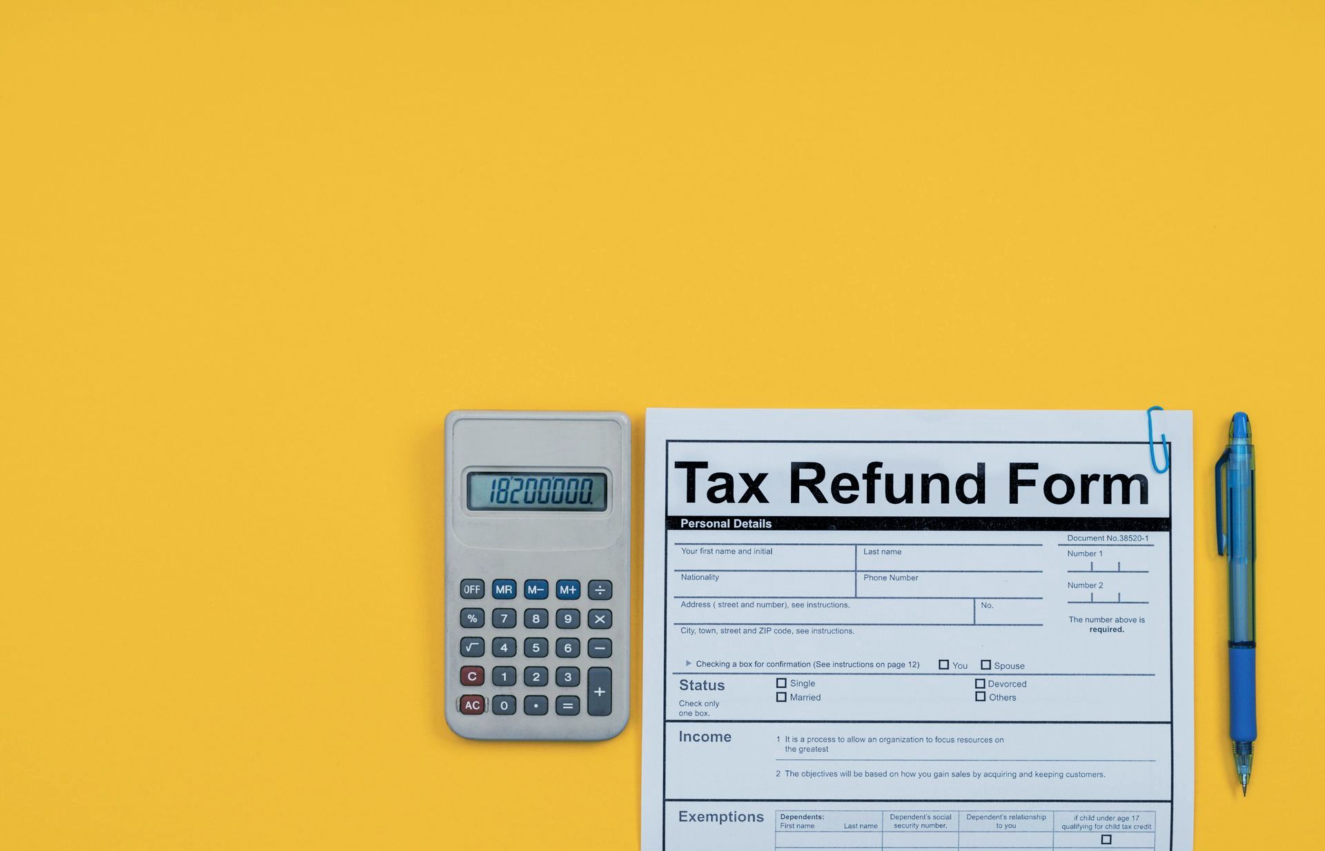 A tax refund form with a calculator and pen on a yellow background.