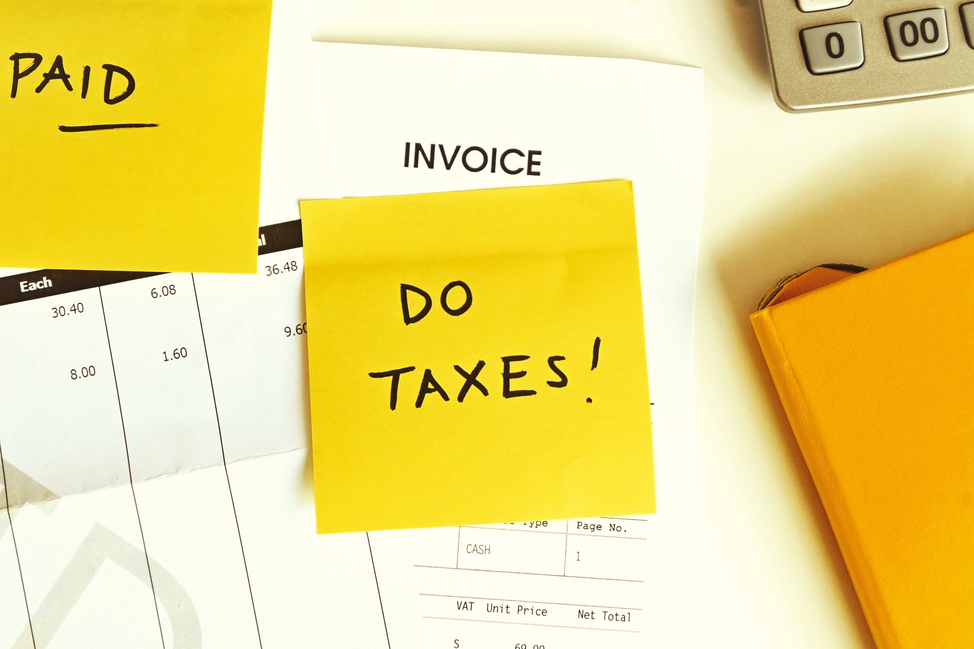 A yellow sticky note that says do taxes on top of an invoice