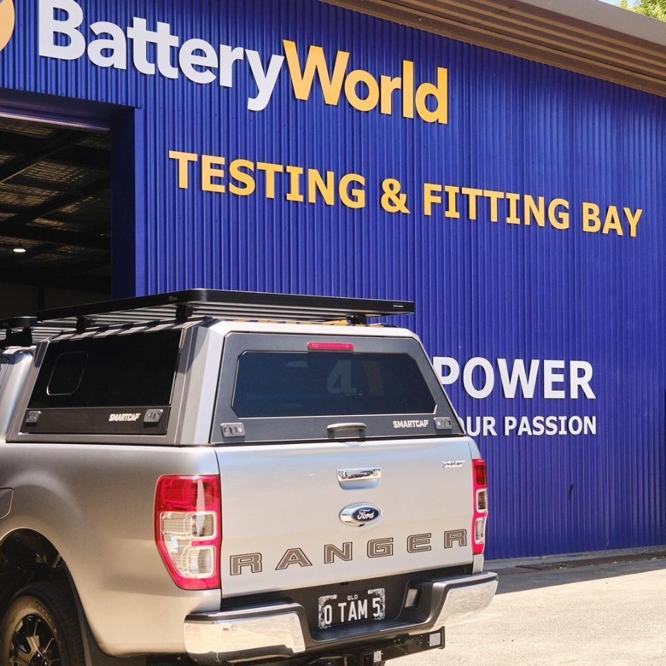 A Silver Truck is Parked in Front of a Blue Building That Says Battery World — Battery World Townsville In Garbutt, QLD