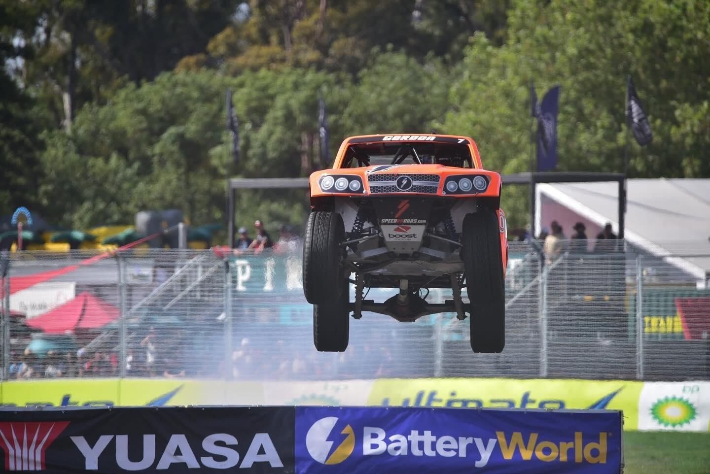 A Truck is Jumping Over a Sign That Says Yuasa Battery World — Battery World Townsville In Garbutt, QLD