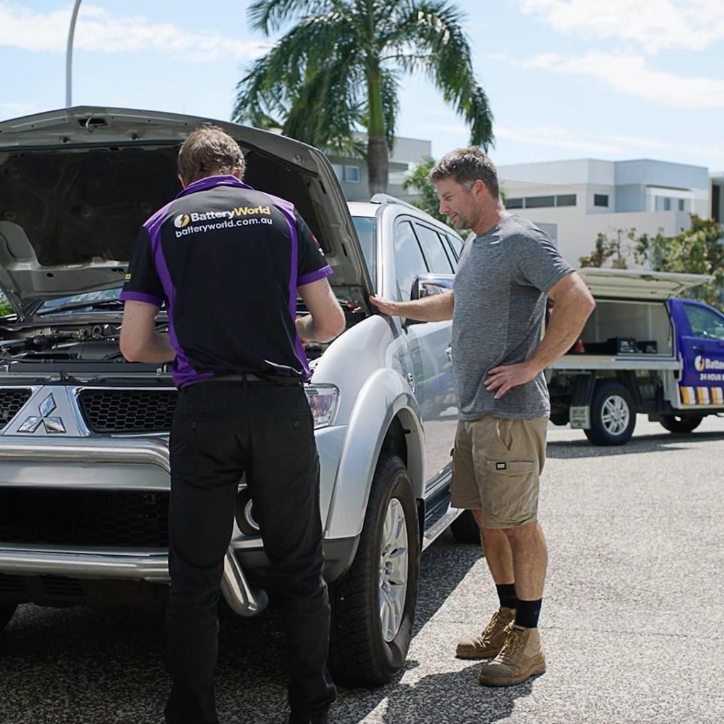 Two Men Are Looking Under the Hood of a White Truck — Battery World Townsville In Garbutt, QLD
