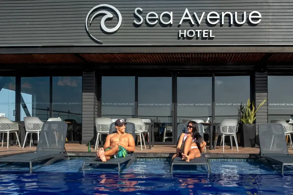 Pareja recostada en camastros del rooftop del Hotel Sea Avenue San Andrés, disfrutando el sol y la vista al mar Caribe en un ambiente romántico.