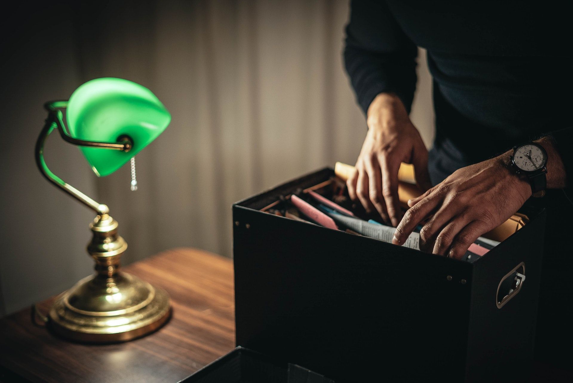 businessperson looking through documents in a box