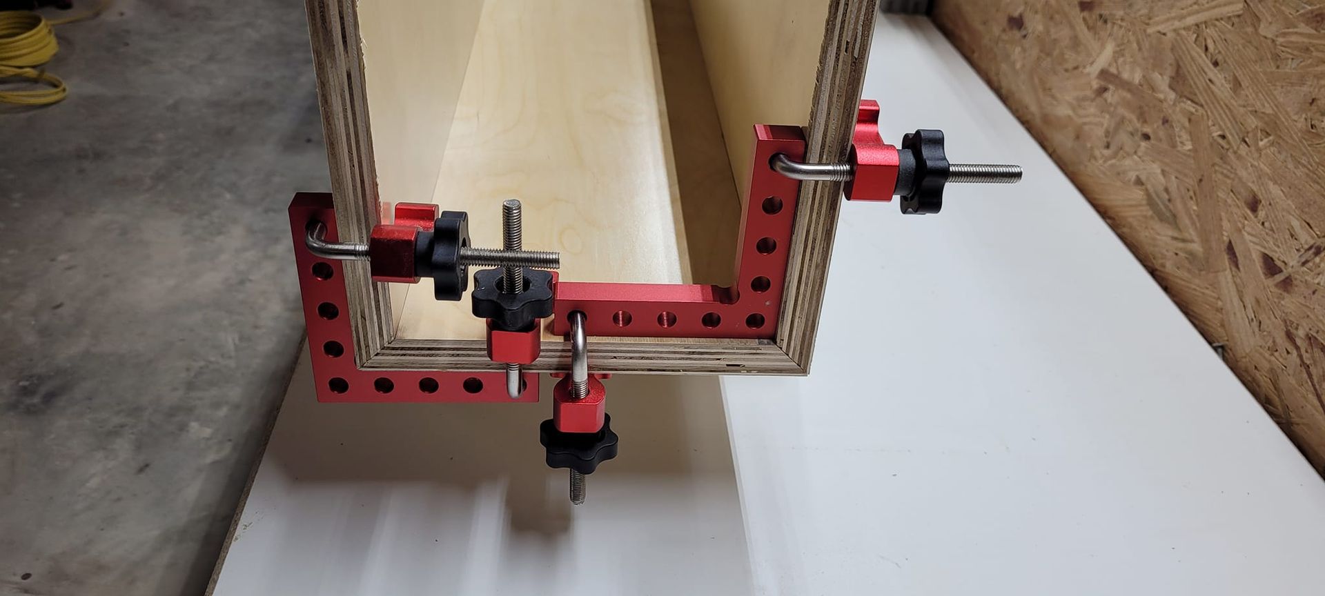 A piece of wood is being glued together with a clamp.