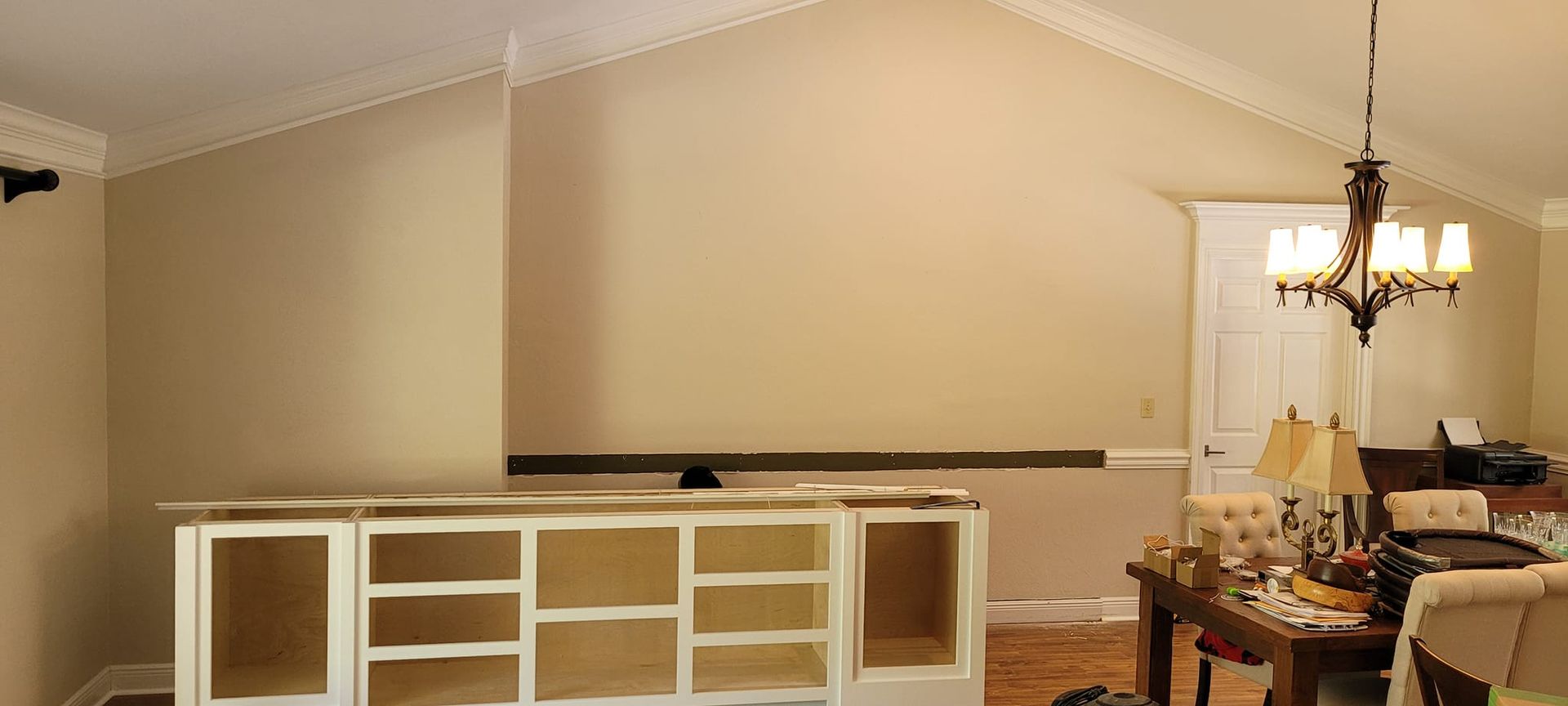 A living room with a vaulted ceiling and a dining room with a table and chairs