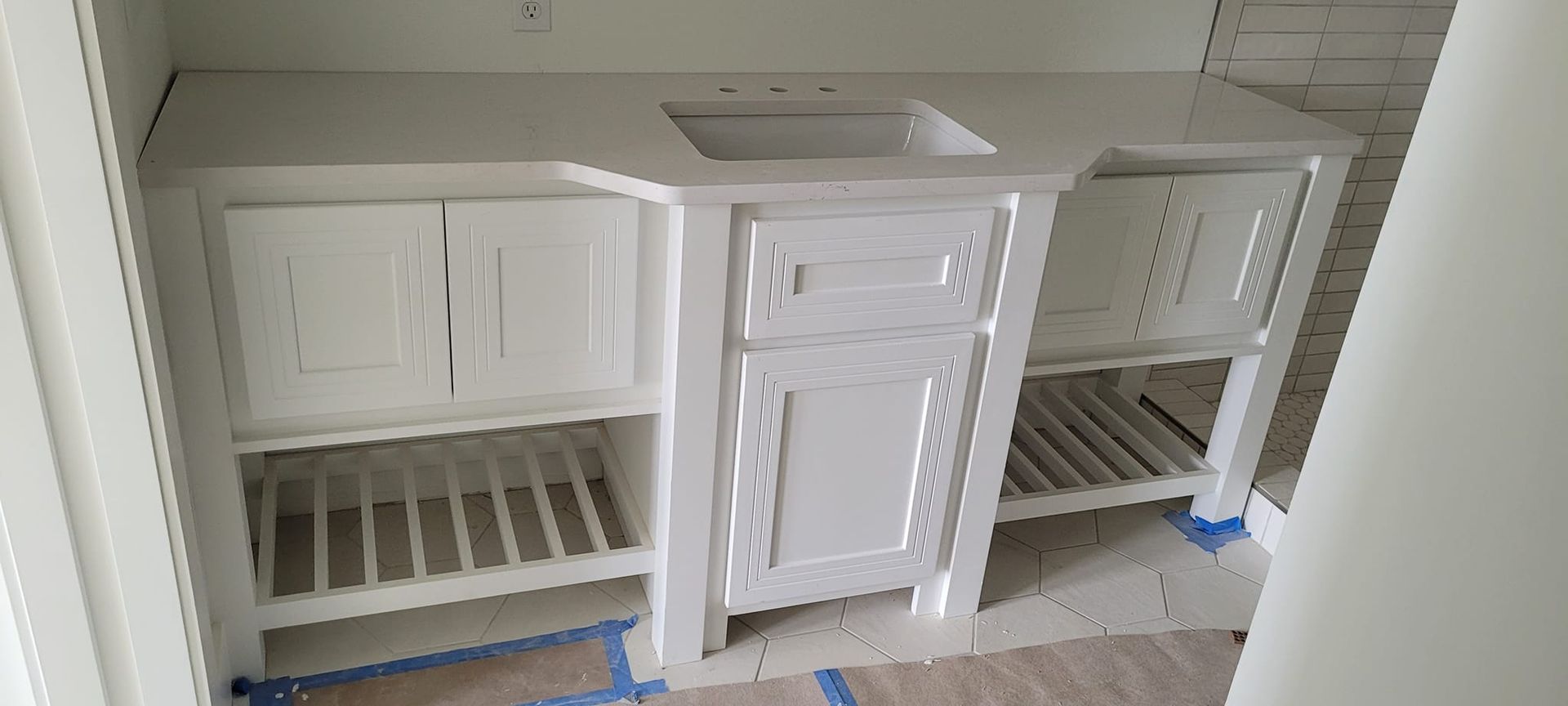 A bathroom vanity with a sink and cabinets in a room.