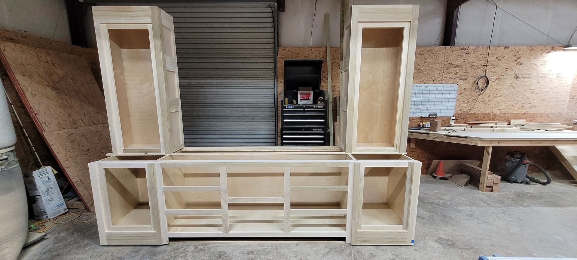 A wooden cabinet is being built in a workshop.
