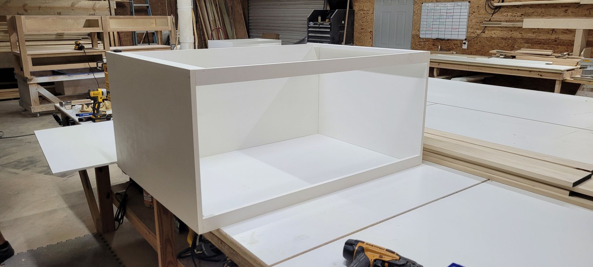 A white box is sitting on top of a wooden table in a workshop.