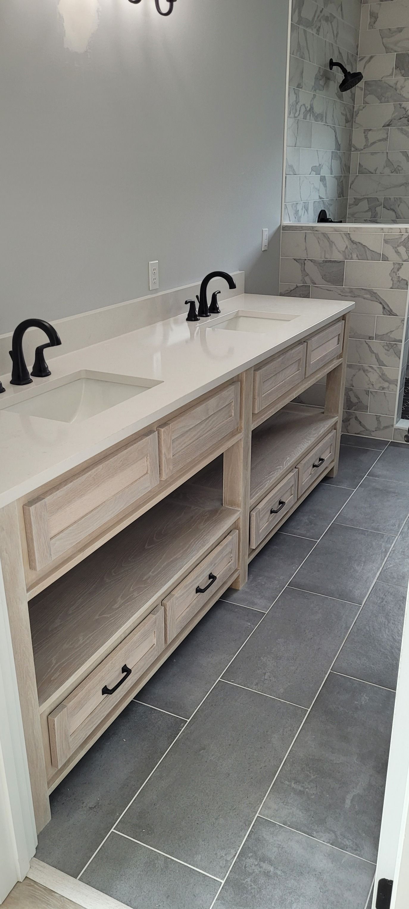 A bathroom with two sinks and a shower.