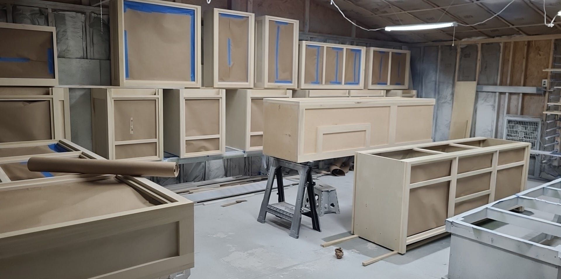 A room filled with lots of wooden cabinets being built.