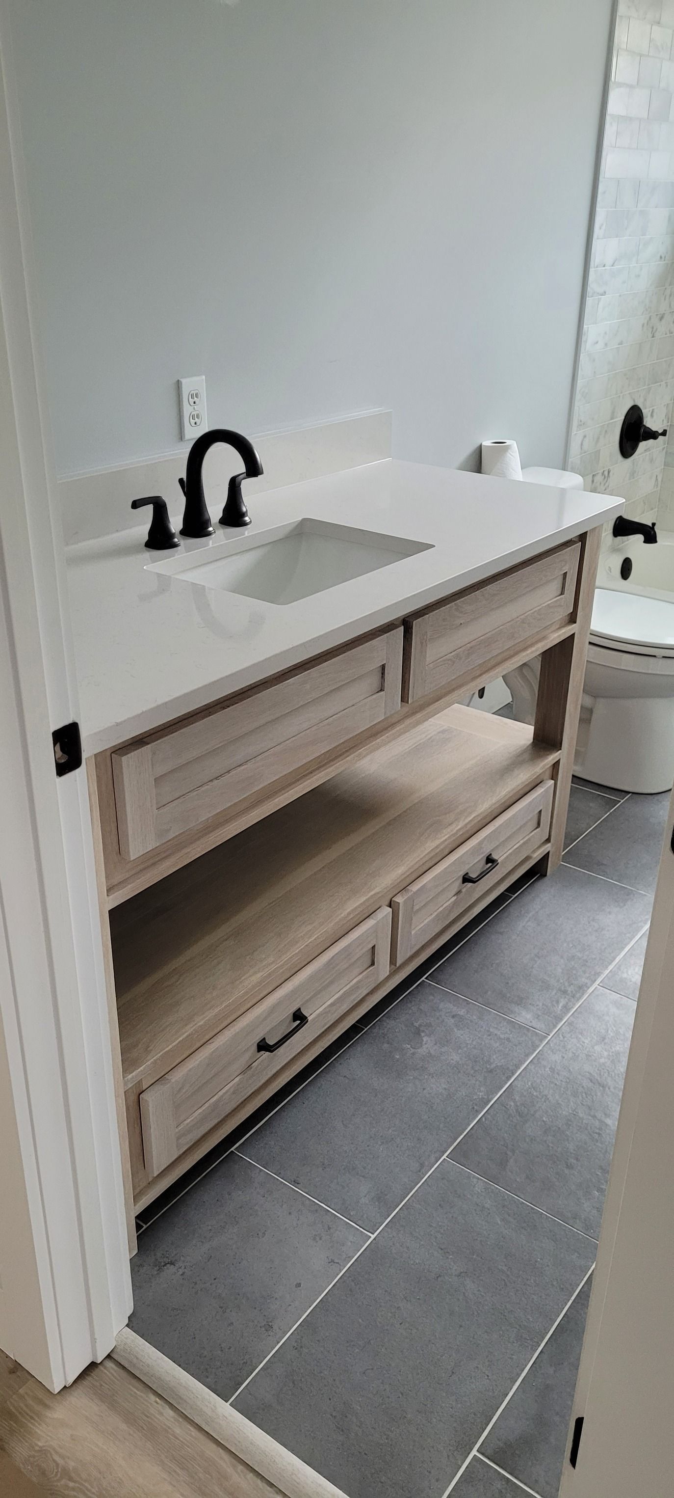 A bathroom with a sink , toilet and shower.