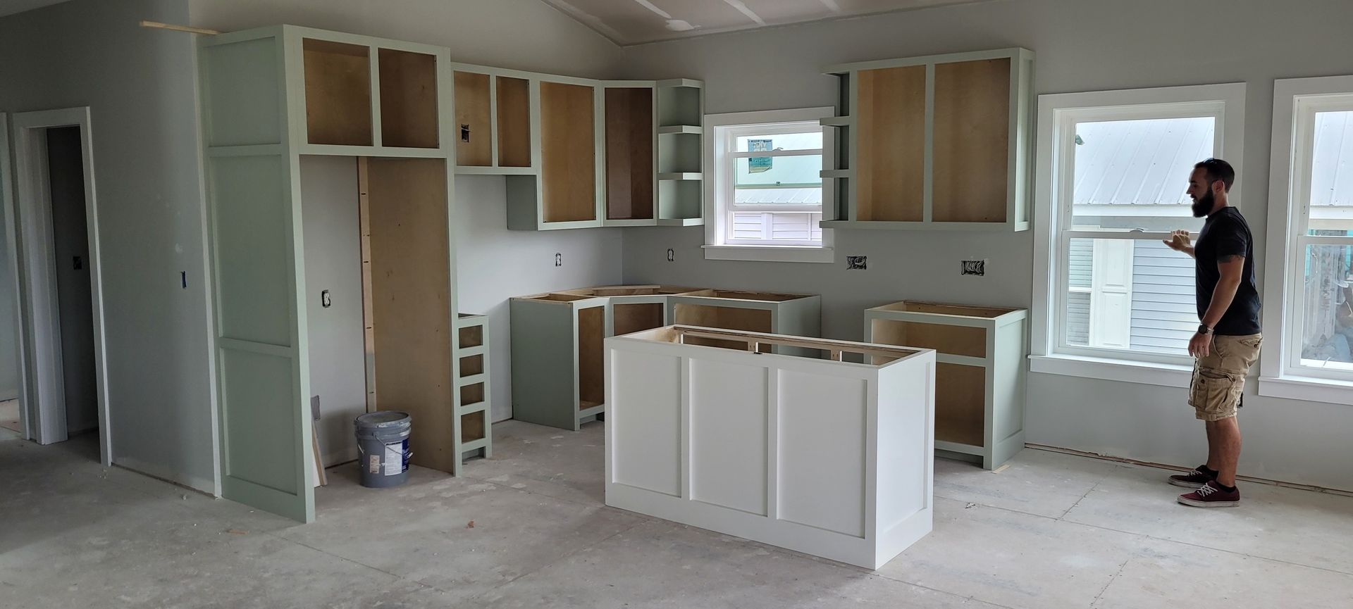 A man is standing in a kitchen under construction.