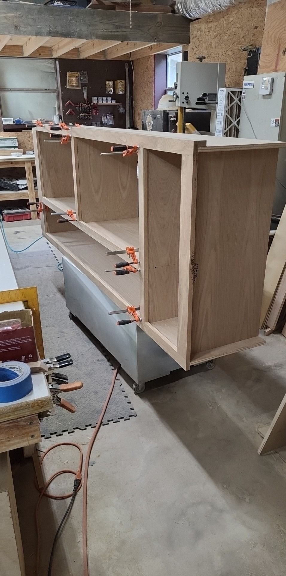 A wooden shelf is being built in a workshop.
