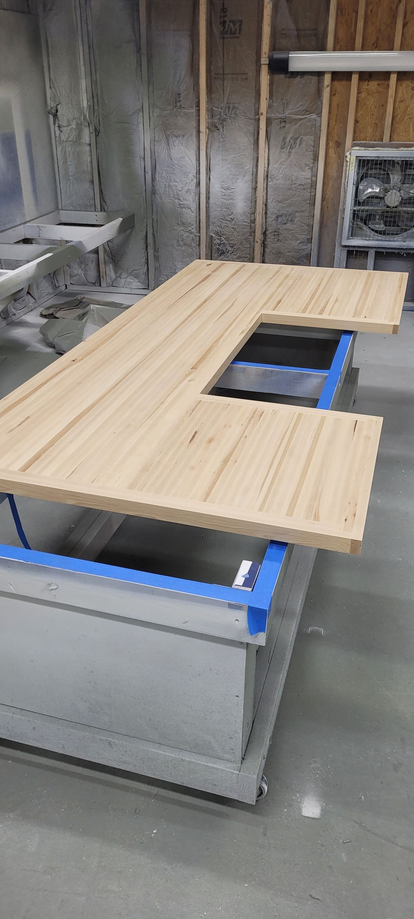 A wooden table is sitting on top of a concrete floor in a room.