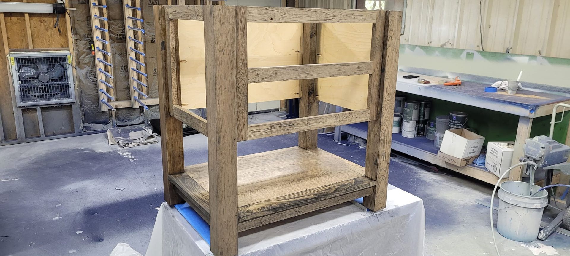 A wooden chair is sitting on top of a table in a room.