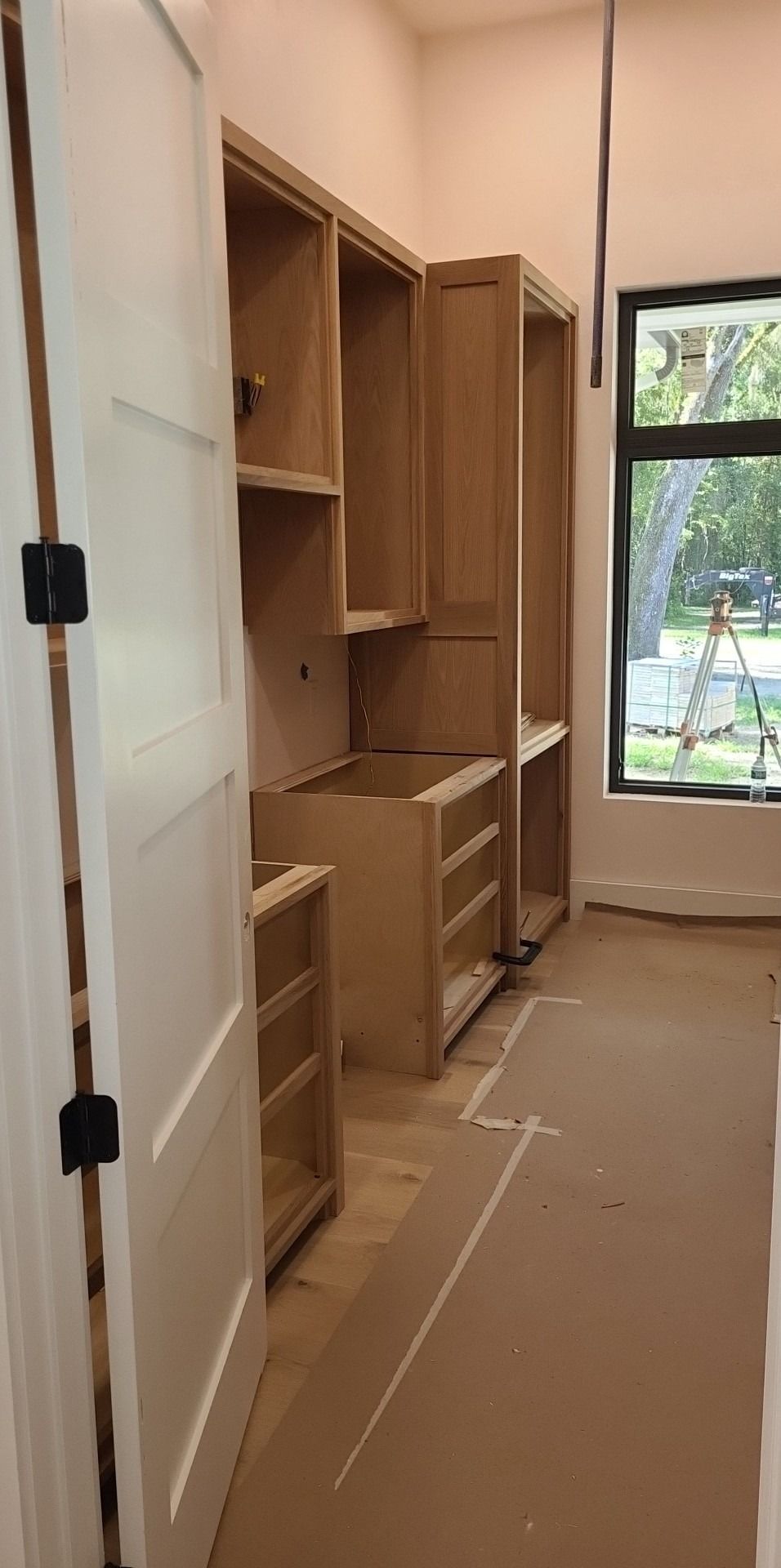 A room with a lot of wooden cabinets and a window.