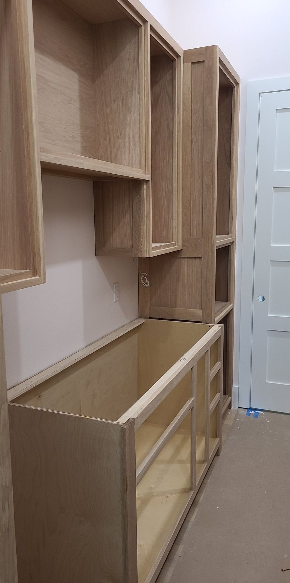 A room with a lot of wooden cabinets and shelves.