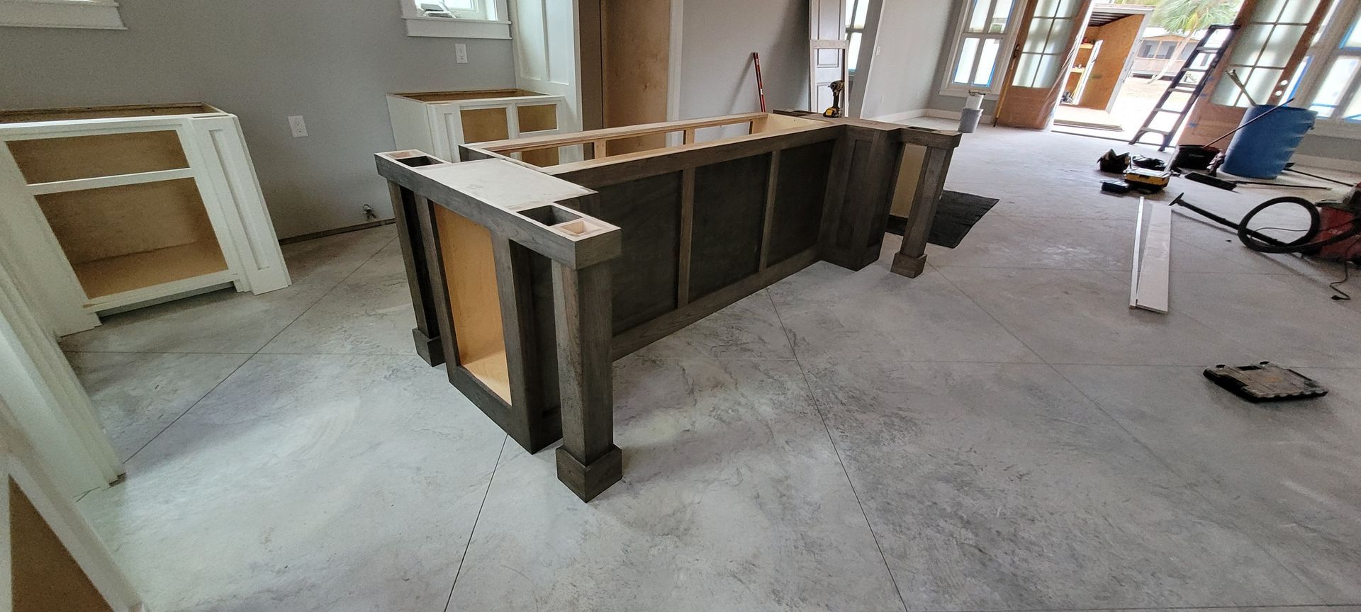 A wooden table is sitting on the floor in a room under construction.