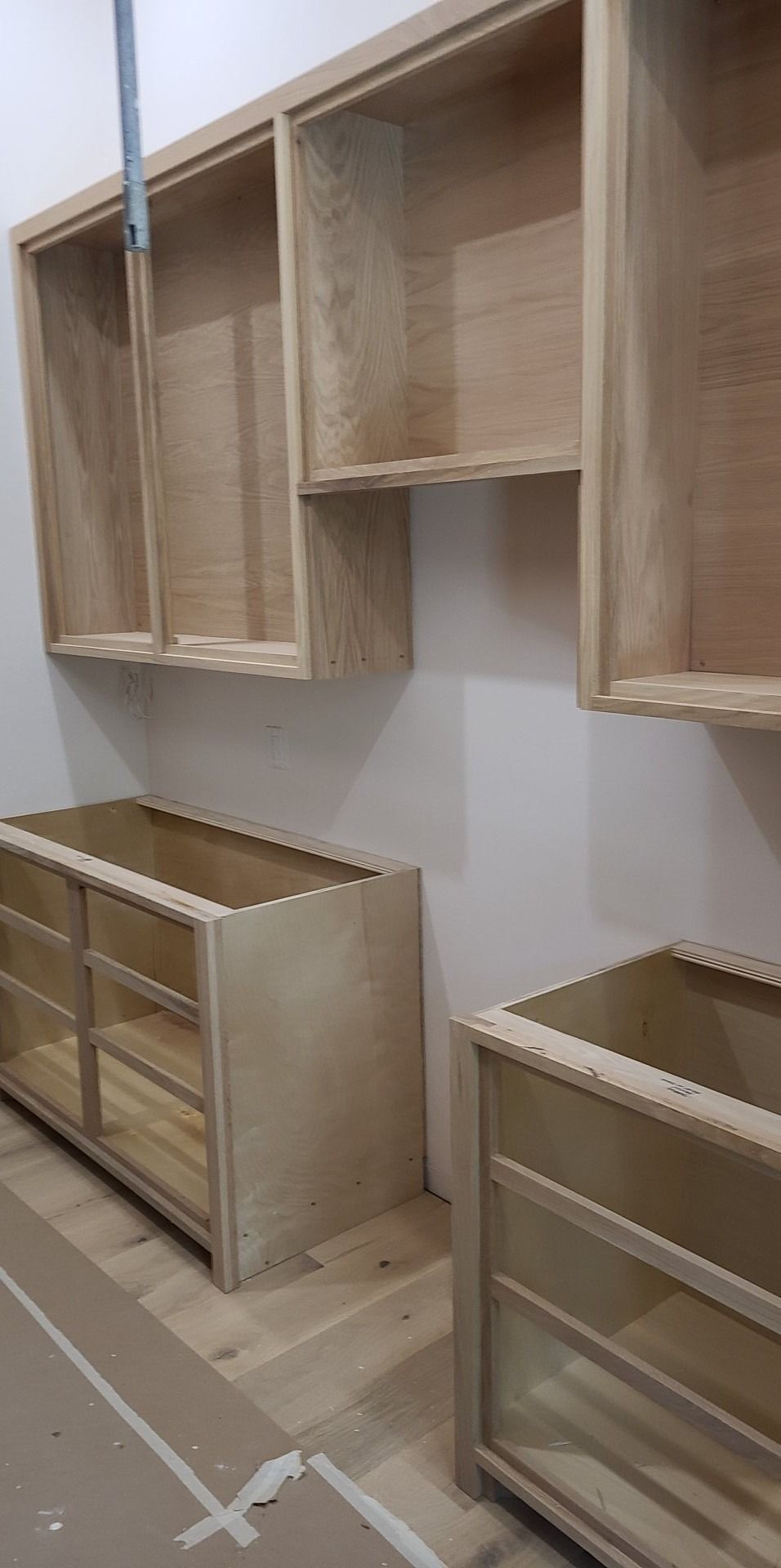 A room with a lot of wooden cabinets and shelves.
