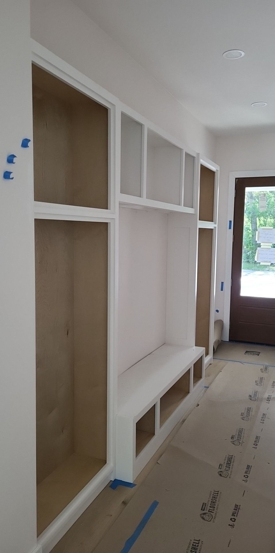 A room with a lot of shelves and a bench in it.