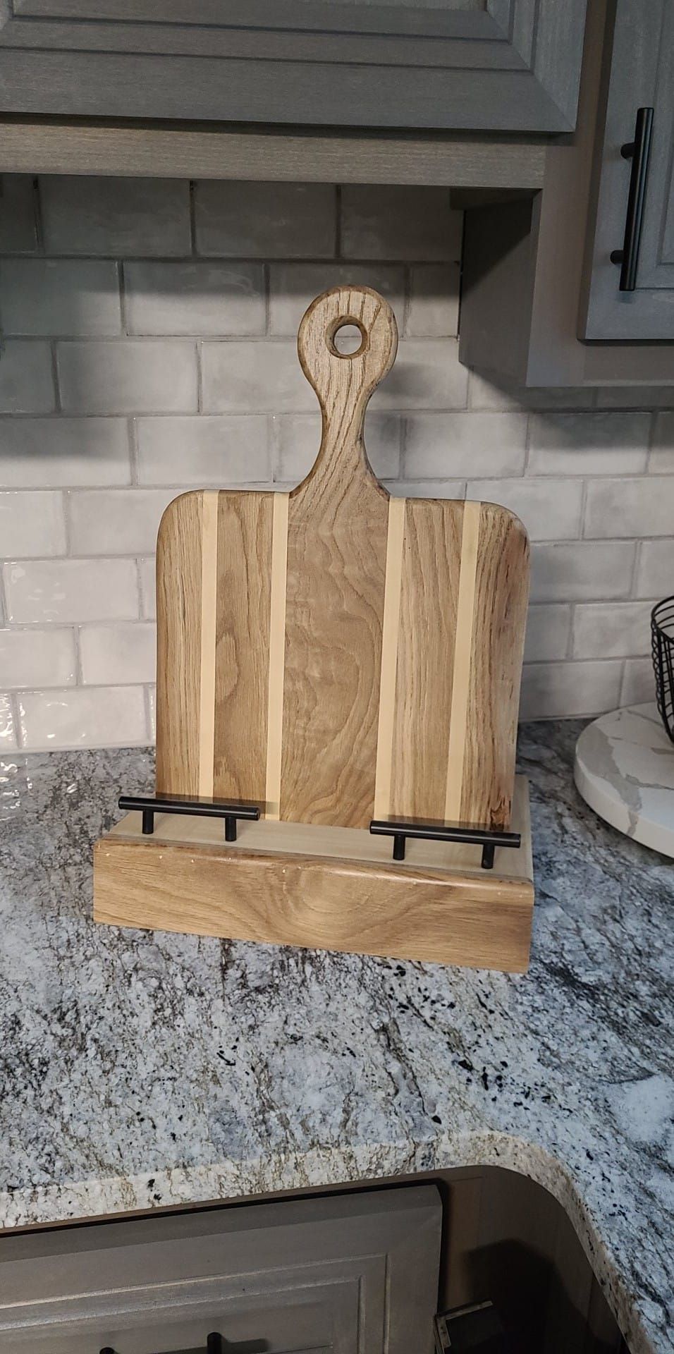 A wooden cutting board is sitting on top of a granite counter.