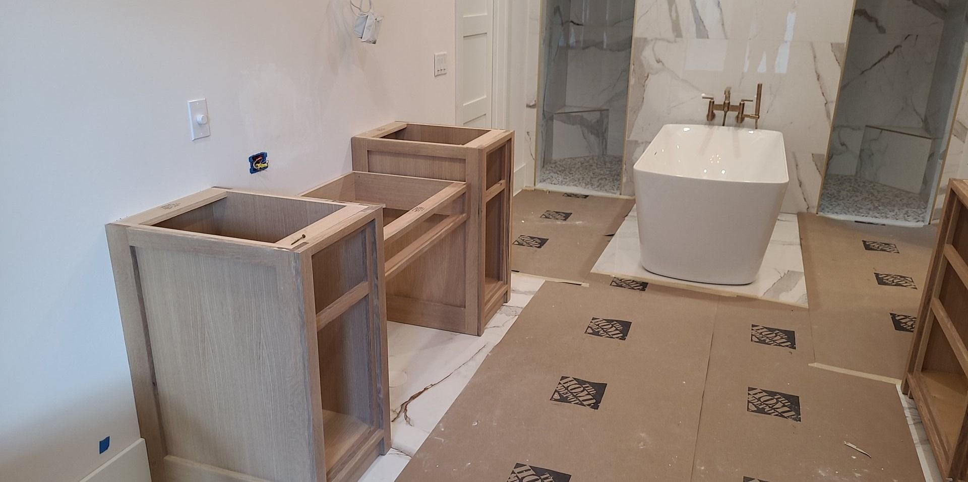 A bathroom under construction with wooden cabinets and a bathtub.