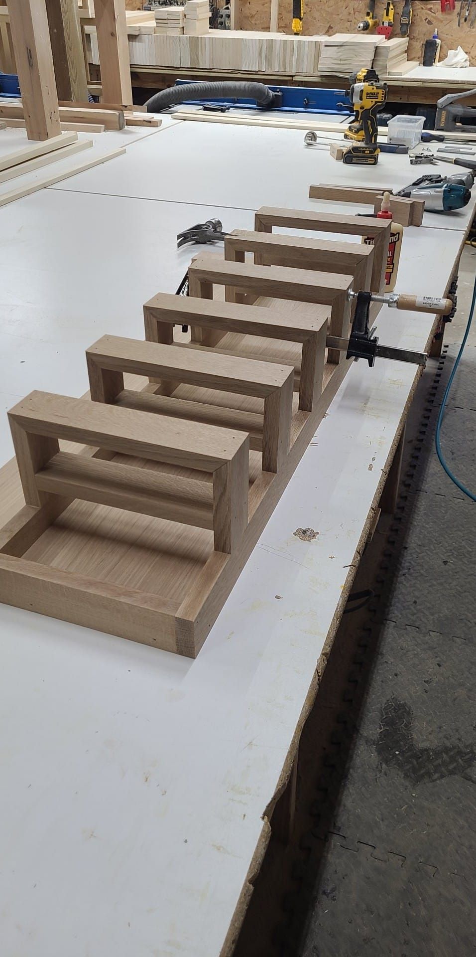 A row of wooden benches are sitting on top of a white table.