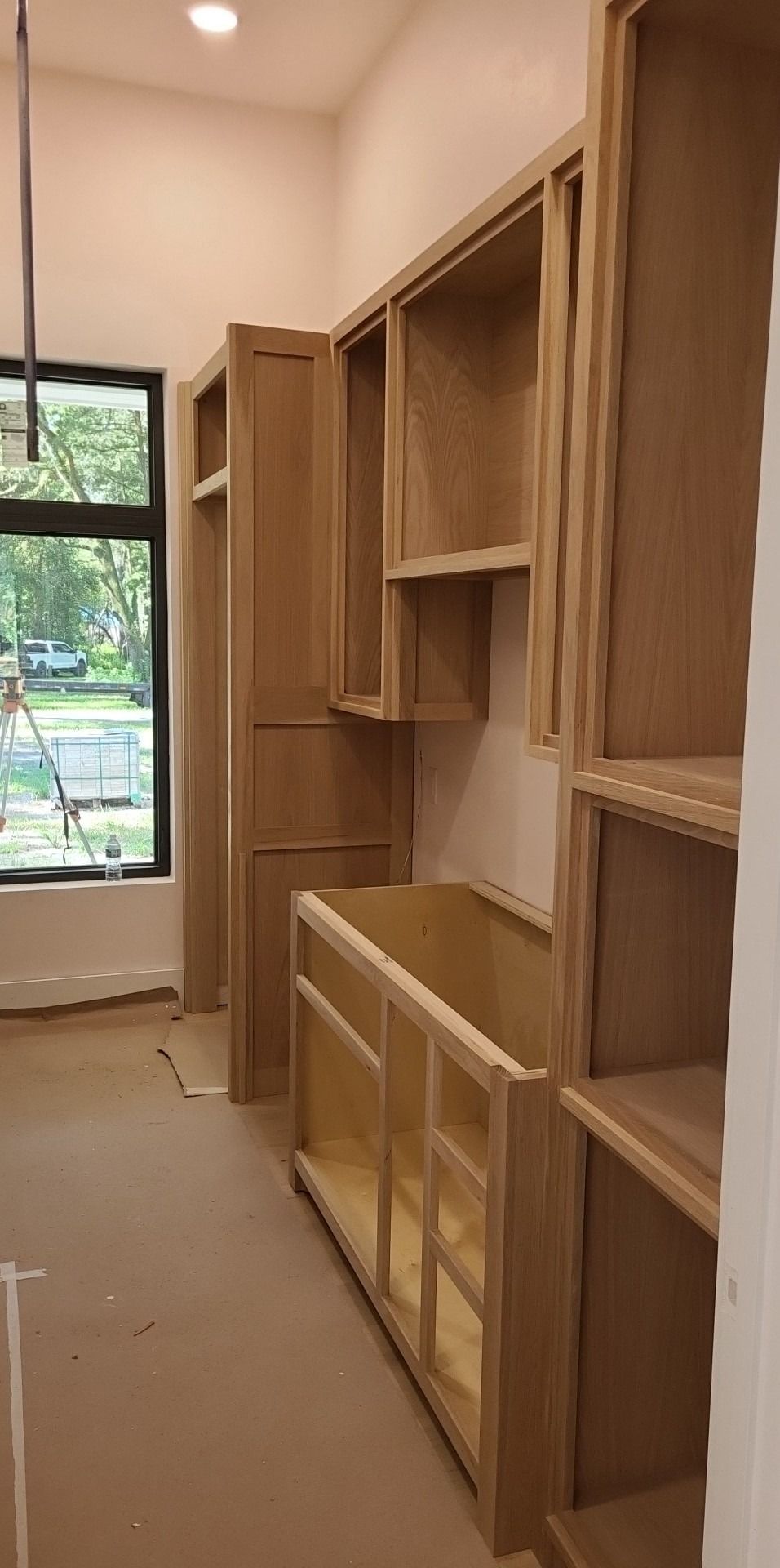 A room with a lot of wooden cabinets and shelves.
