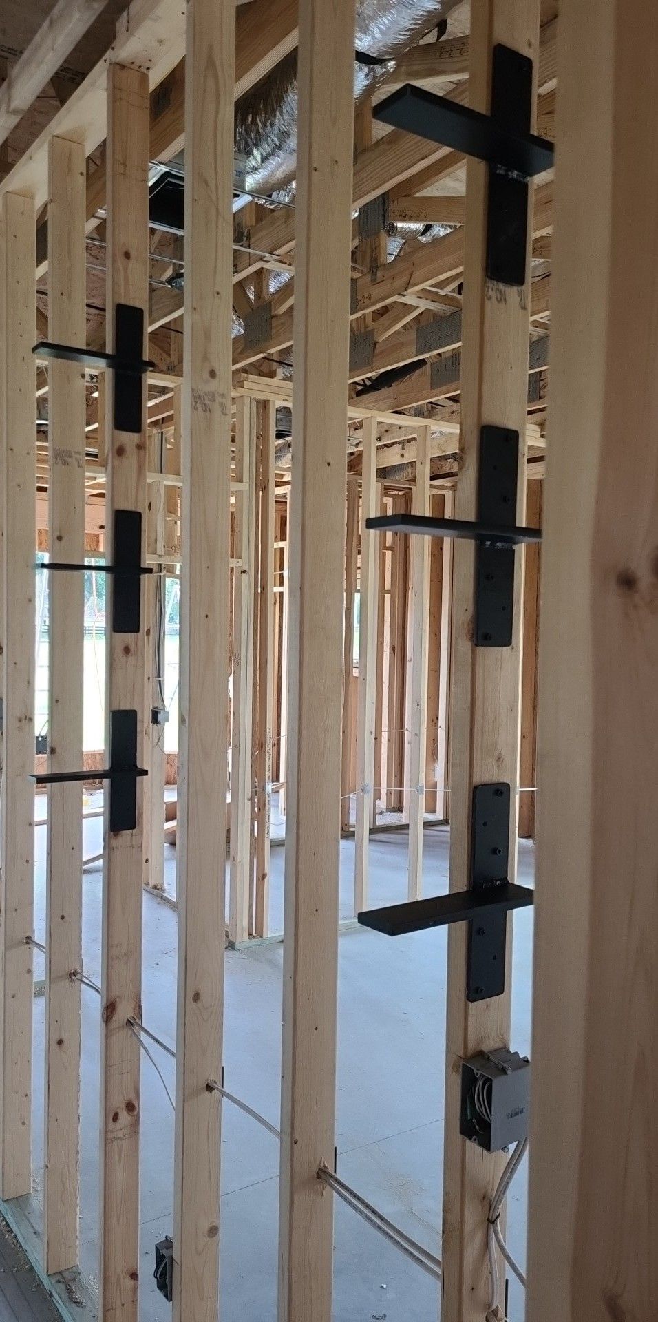 A house is being built with wooden beams and metal brackets.