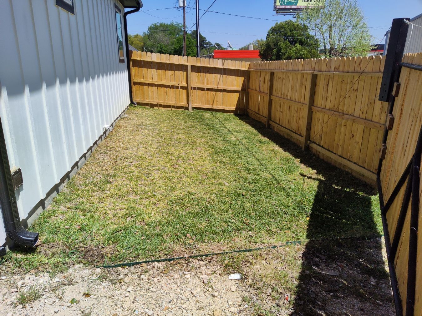 There is a wooden fence in the backyard of a house.
