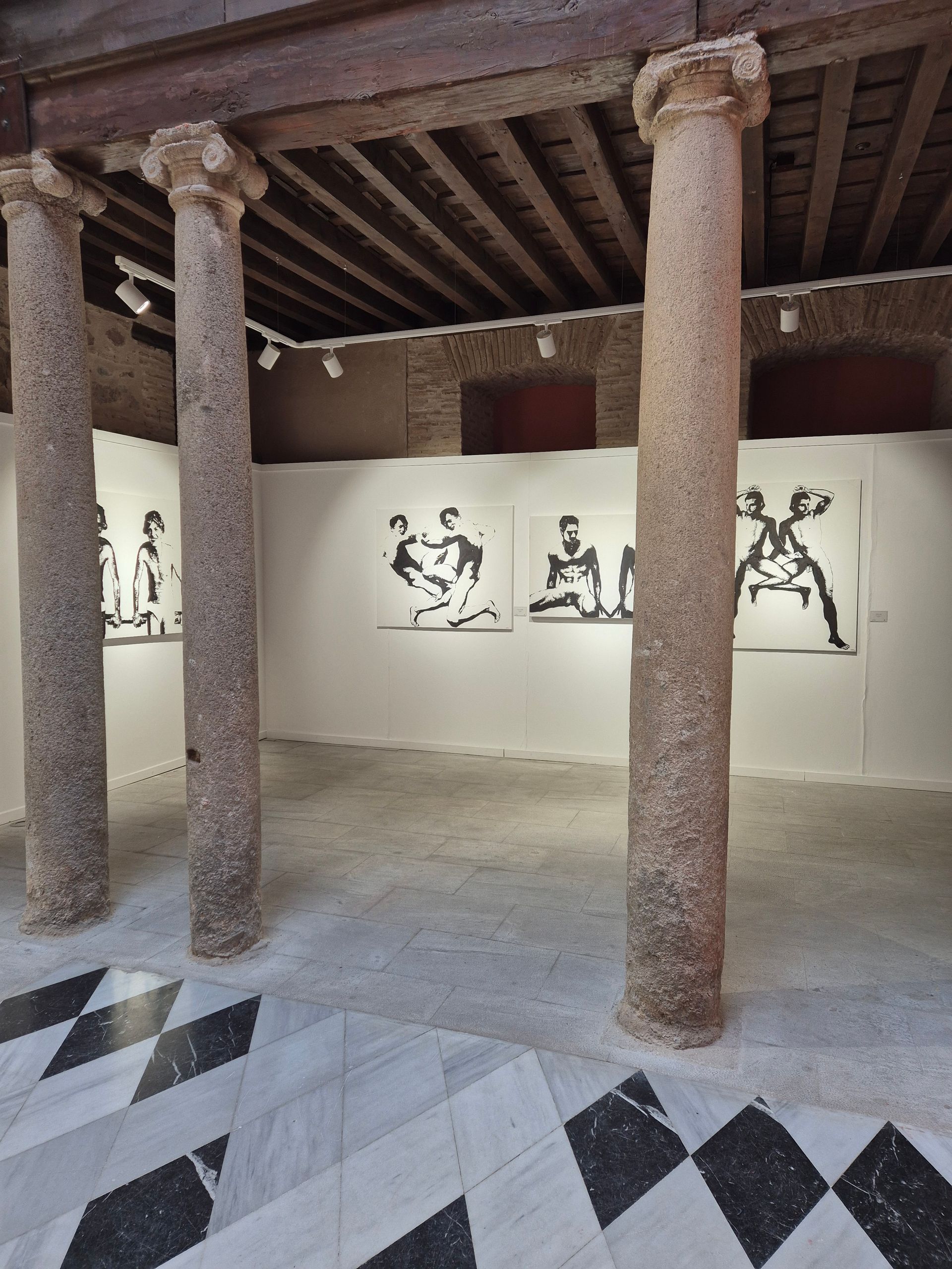 Un museo con columnas y pinturas en la pared.