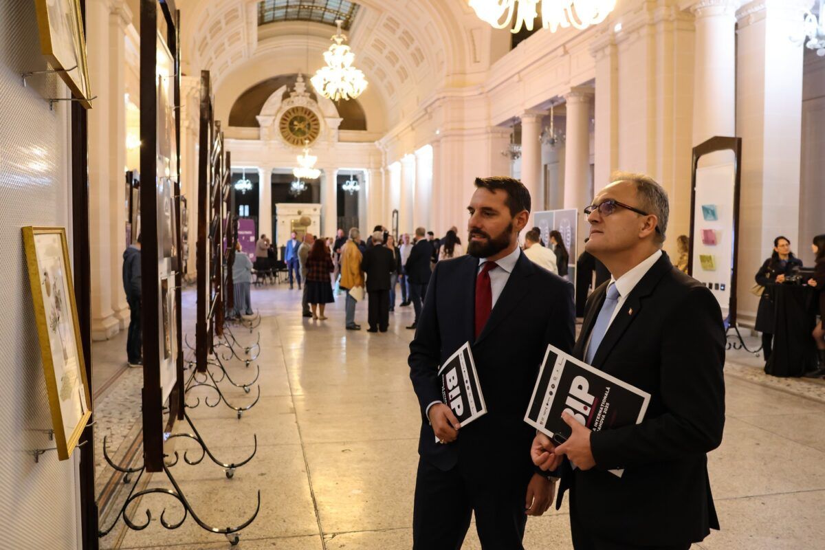 Principe Nicolae de Rumania observa arte en la inauguración la Biienale, con otros asistentes en el fondo.