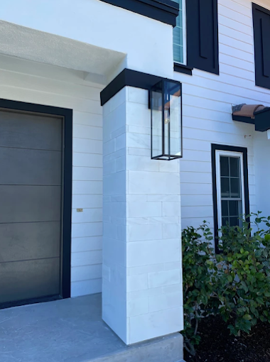 A white house with black trim and a black garage door