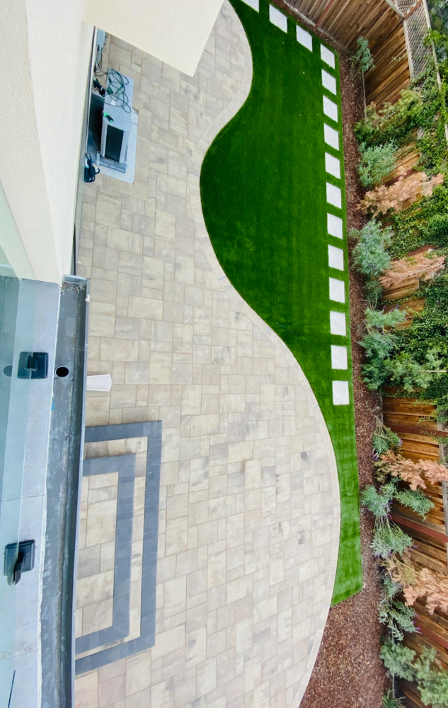 An aerial view of a backyard with a patio and grass.