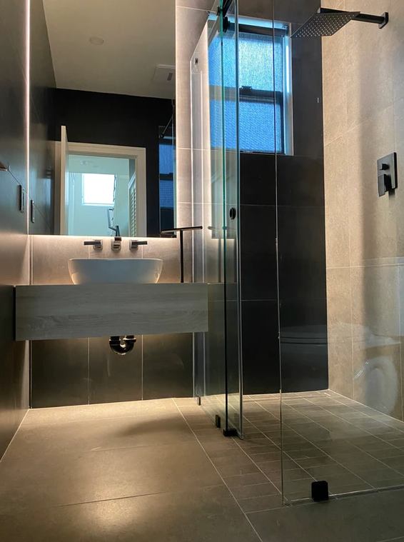 A bathroom with a sink and a shower stall