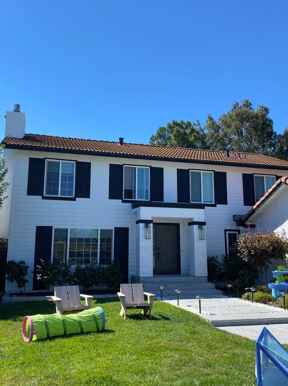 A white house with black shutters on the windows