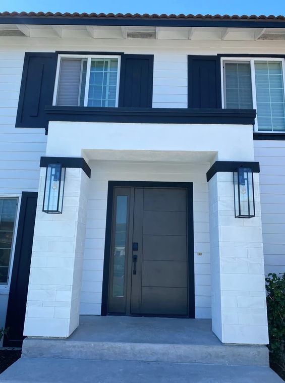 A white house with black shutters and a black door