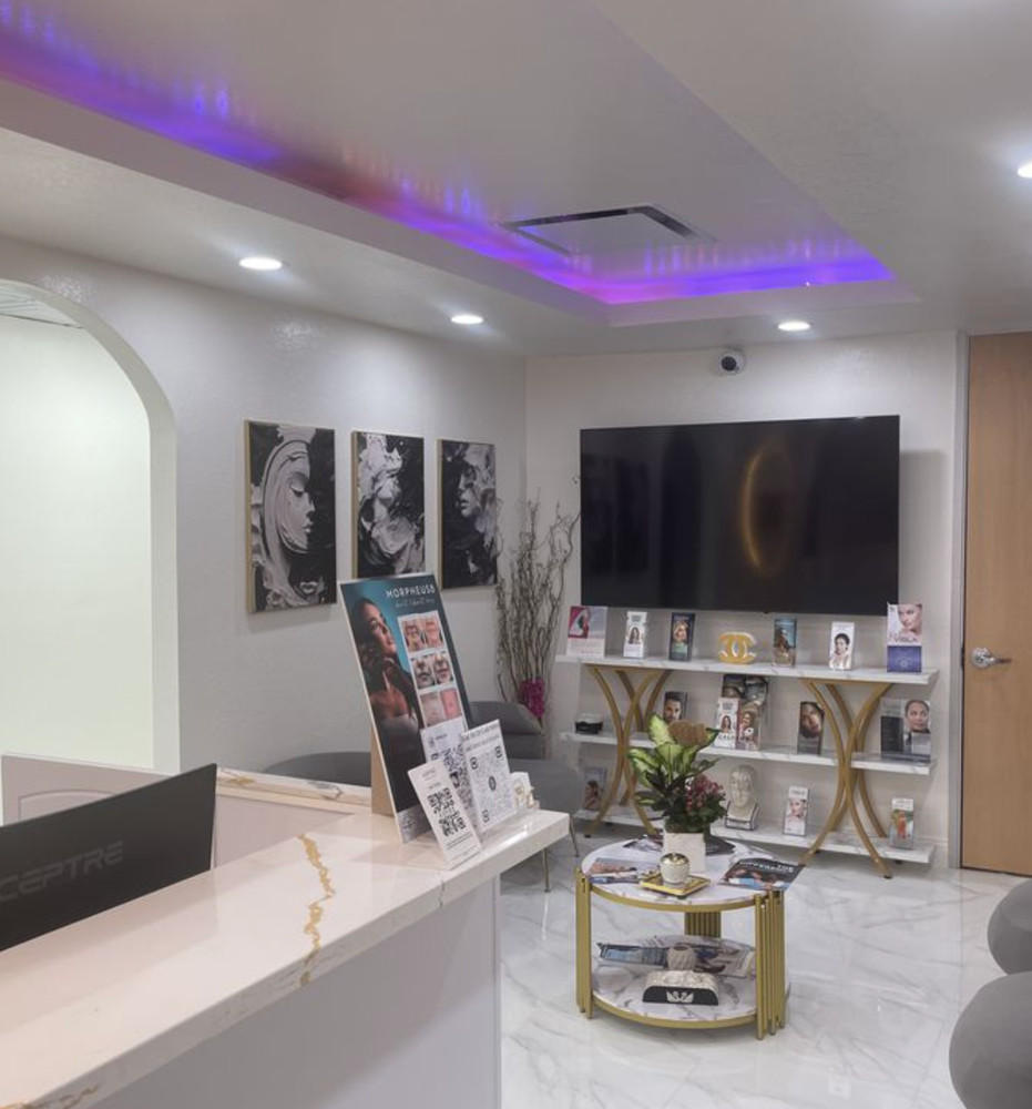 A waiting room with a table and a flat screen tv