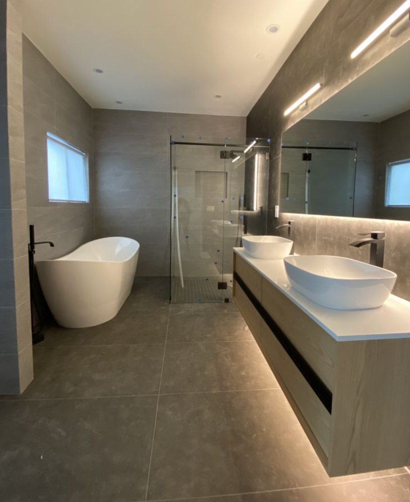 A bathroom with two sinks , a bathtub and a shower.
