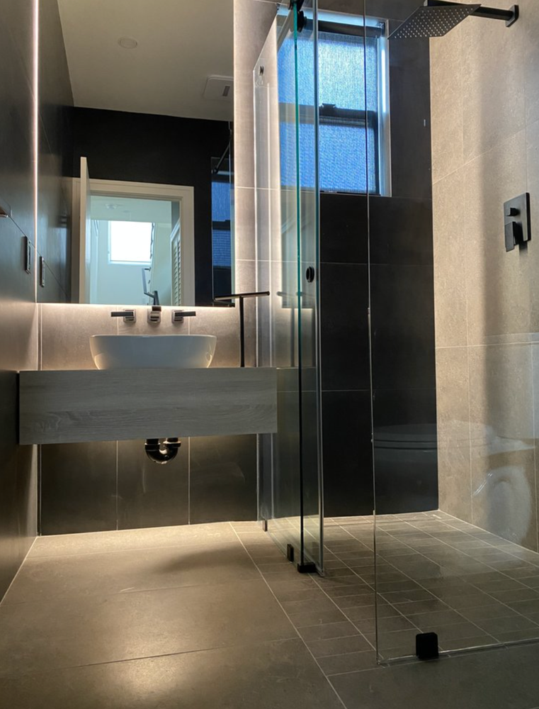 A bathroom with a sink and a shower stall