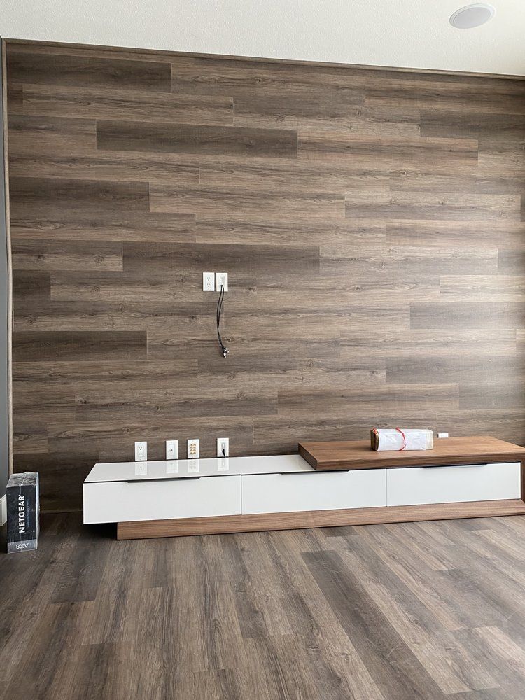 A living room with a wooden wall and a wooden floor.