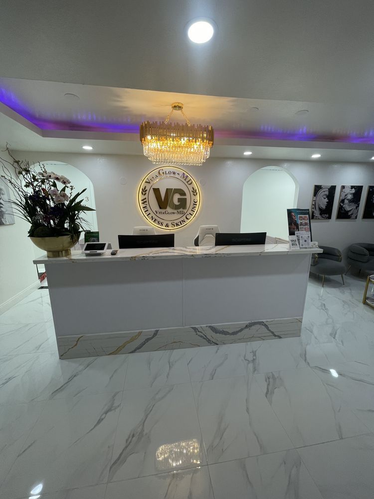 A reception desk in a medical office with a chandelier hanging from the ceiling.