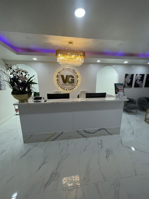 A reception desk in a medical office with a chandelier hanging from the ceiling.