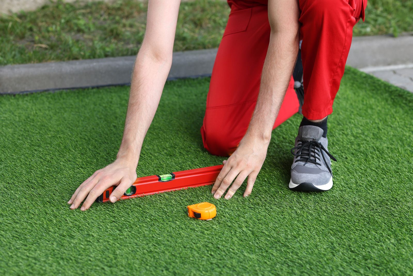 A person is measuring a lawn with a level.