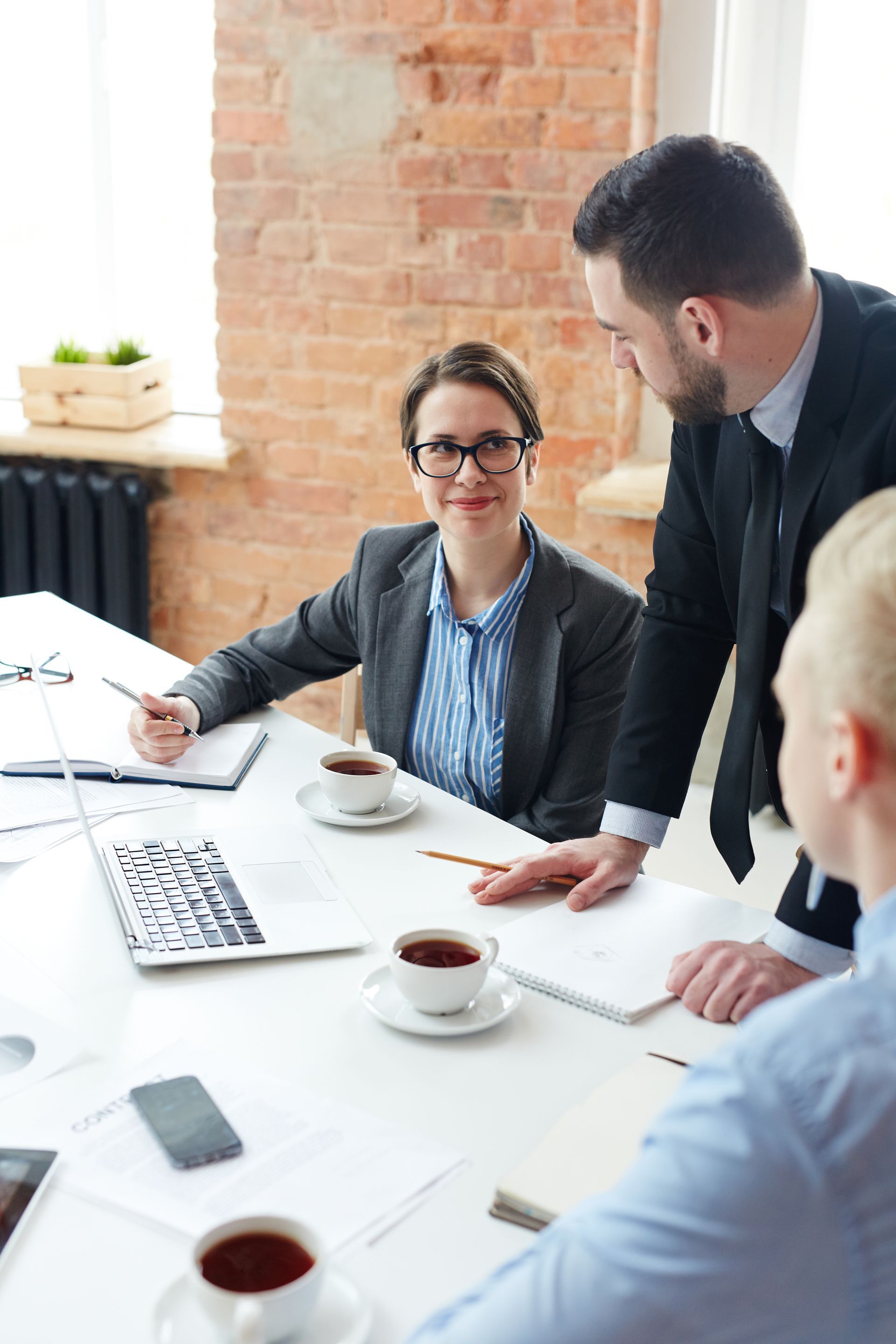 a group of people are sitting around a table having a meeting .