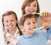 Mother and two children brushing teeth — Family Dentistry in Cheyenne, WY